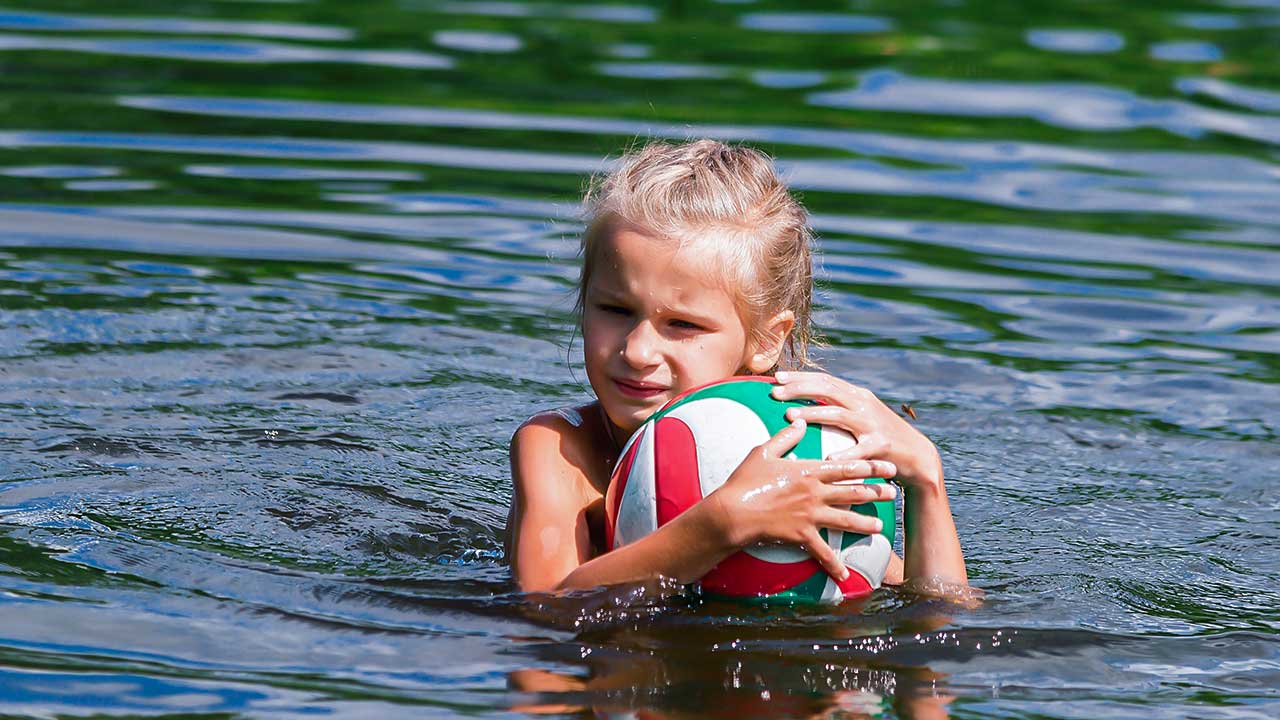 Mädchen mit Ball im Wasser
