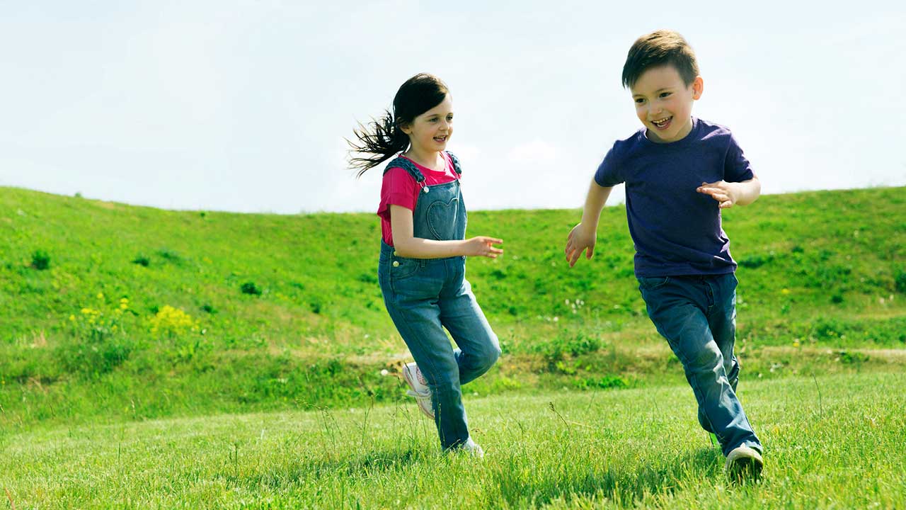 Kinder rennen über eine Wiese